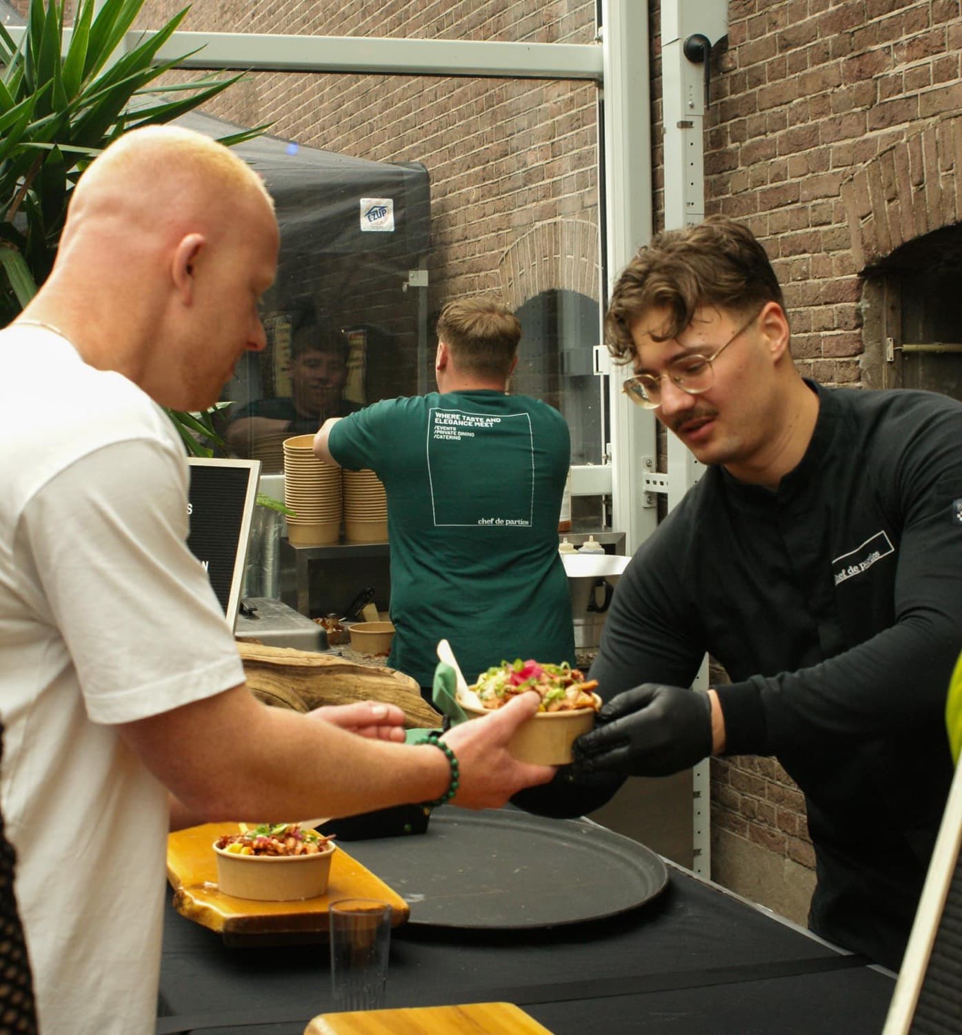 Chef overhandigt een vers afgemaakte bowl aan een gast