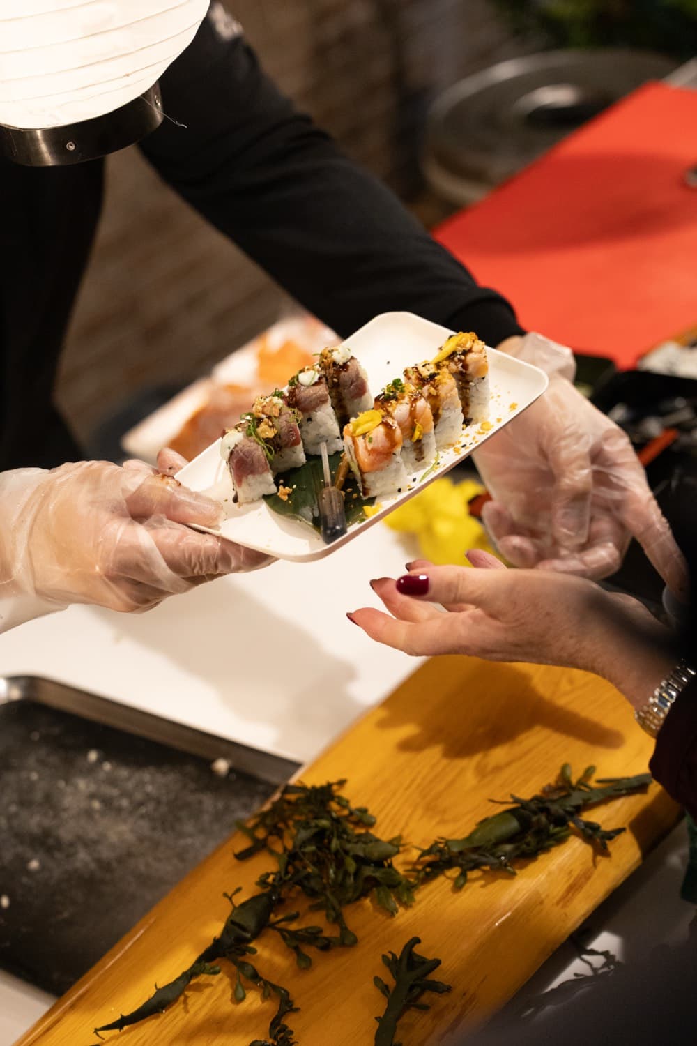 Vers gemaakte sushirolls worden over de counter aangereikt