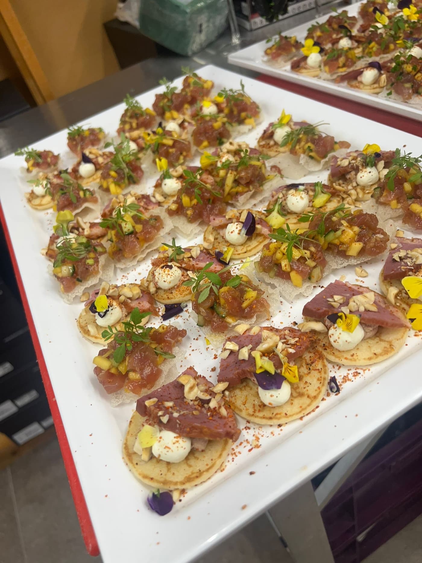 Blini's met tonijntartaar en gerookte eend op een uitserveerschaal